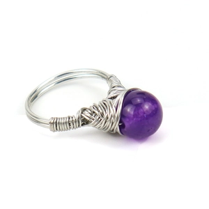 Handmade silver wire wrapped ring featuring a polished round purple amethyst crystal bead