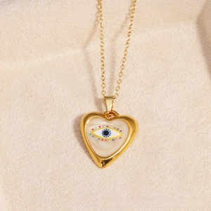 Macro detail of a gold-plated heart pendant with a colorful evil eye motif on a fine O-chain