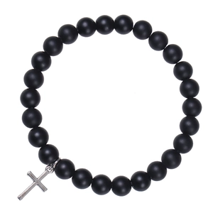 Close-up of black matte beaded bracelet featuring a silver metal cross pendant detail