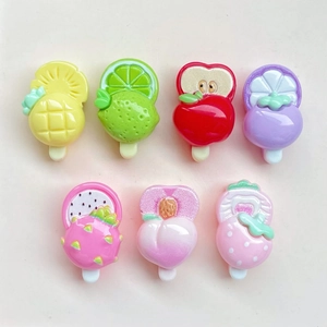 Detailed top view of assorted mini resin fruit popsicles including strawberry and apple designs