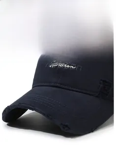 Macro detail of white Narason embroidery and distressed brim on navy cotton baseball cap
