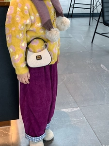 Gros plan d'un sac à main tissé pour enfant assorti à un pull à imprimé léopard tendance