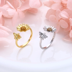 Detailed macro view of S925 sterling silver sunflower and bee rings with inlaid zircons