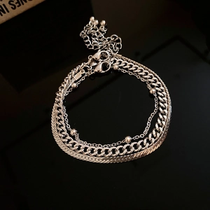 Detailed macro of layered silver metal chains including Cuban and snake link styles