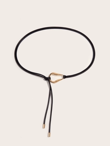 Detail of a black leather knot belt with a streamlined gold buckle and metal tips