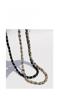 Close-up of black onyx and cow pattern stone beads with metallic silver spacers