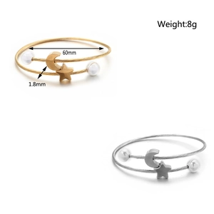 Dettaglio del bracciale rigido da 60mm con ciondoli a luna, stella e perle eleganti