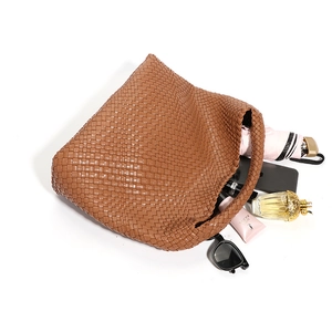 Brown hand-woven tote bag with large capacity shown with daily essentials on white background