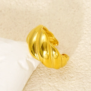 Detailed macro shot of a gold-plated croissant ring with spiral texture on white stone