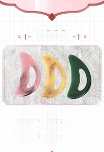 Close-up of three large resin gua sha tools with ergonomic finger holes and smooth curves