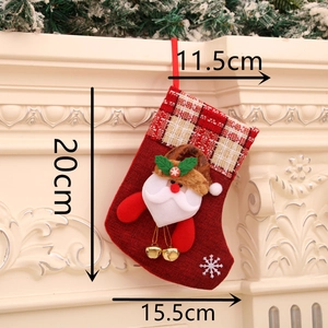 Détail de la botte de Noël en toile rouge avec Père Noël et clochettes sur une cheminée