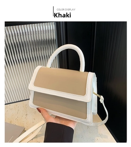 Detail view of khaki and beige contrast PU leather handbag with gold metal hardware