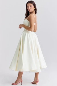 Close-up of the elegant layered mesh hem and satin finish on this ivory midi dress