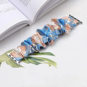 Detail of blue and orange plaid scrunchie watch band with golden stars for Apple Watch
