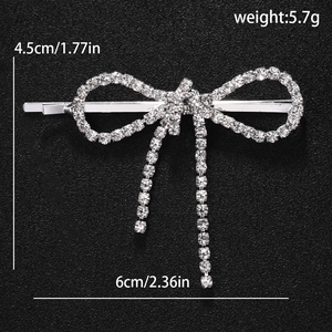 Silver bow hair clip with rhinestones showing dimensions 6cm by 4.5cm and weight 5.7g