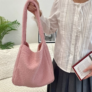 Detailed texture of pink teddy fleece tote bag with soft shoulder strap in a cozy setting