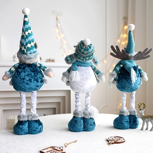 Close-up of three blue and white Christmas plush dolls featuring deer and snowman motifs