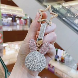Sparkling rhinestone rabbit keychain with star buckle shown in hand close-up