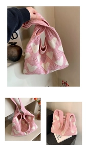 Detail of pink knitted shoulder bag featuring white heart jacquard and woven texture