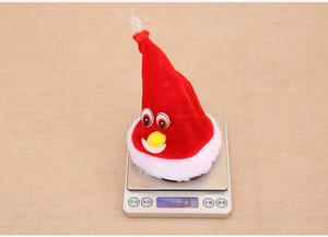 Détail d'un bonnet de Noël musical sur une balance numérique affichant un poids de 73g