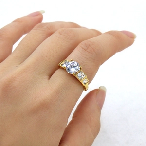 Close-up of a gold-tone stainless steel ring featuring round and square sparkling zircons
