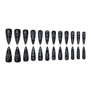 Black stiletto press-on nails with white mystical alchemical symbols and geometric patterns