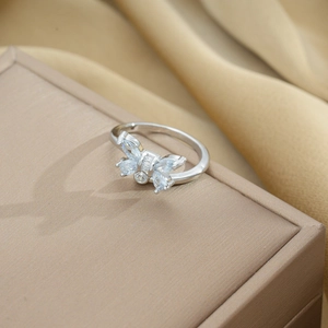 Macro detail of silver butterfly ring with marquise cut zircon on beige jewelry box
