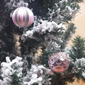 Set of 12 luxury 6cm pink and rose gold textured Christmas ball ornaments on a snowy tree