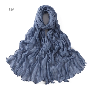 Detail view of the blue breathable linen scarf with elegant twisted crinkle texture