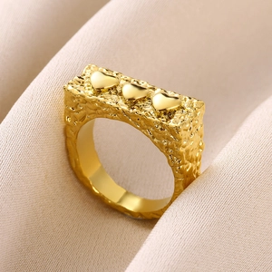 Macro detail of gold chunky ring with irregular lava texture and three polished hearts