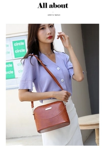 Brown leather crossbody bag with shell design worn by model in casual outdoor setting
