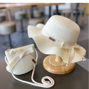 Detail of girls' cream straw sun hat and matching crossbody bag set with leather patch