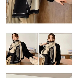 Close-up of contrast knit texture and white stitched edges on a bicolor cashmere scarf