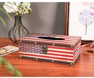 Detail of vintage American flag tissue box with leather texture and metal buckle on wood table