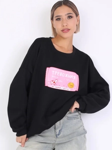 Detailansicht des rosa Kuhdrucks und russischen Textes auf einem schwarzen Sweatshirt