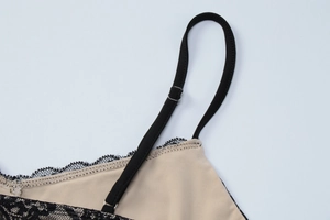 Détail de la bretelle noire réglable et de la bordure en dentelle sur robe beige