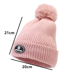 Pink knit winter hat for children featuring a teddy bear patch and measurements 21x20cm