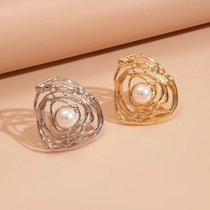 Detailed close-up of irregular hollow gold and silver earrings with elegant white pearls