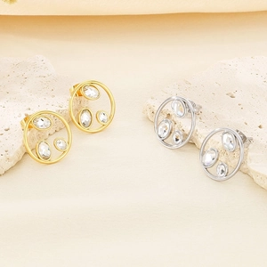 Detailed view of gold and silver hollow circular earrings with inlaid crystals