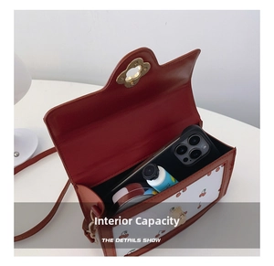 Interior view showing the capacity of a cherry print crossbody bag with a flower clasp