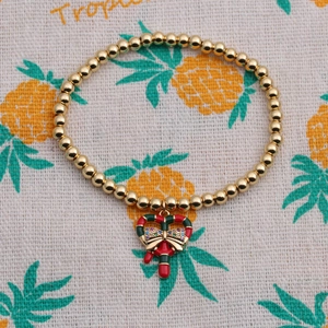 Détail du bracelet de Noël avec charm canne en sucre en émail rouge et vert