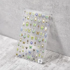 Close-up of thin butterfly nail art stickers in vintage green and purple on grey background