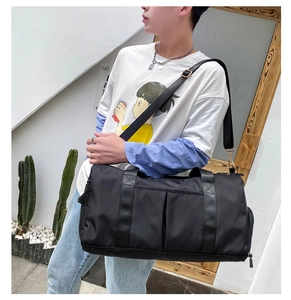 Outdoor shot of a black nylon travel bag with adjustable straps on a male model