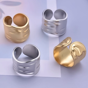 Detailed view of gold and silver irregular textured wide open rings on light purple background