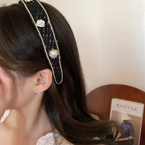 Detail of tweed headband featuring white camellia flower and elegant imitation pearls