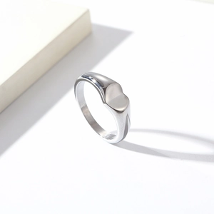 Polished silver heart signet ring with a minimalist geometric face on white background