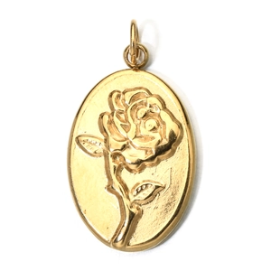 Macro detail of oval gold pendant featuring an embossed rose flower on metallic surface