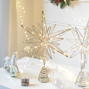 Sparkling gold and silver metal star tree topper with warm LED lights and spring base