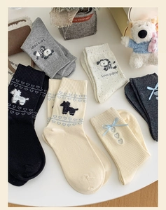 Detail of crew socks featuring flocked puppy motifs and heart patterns on knit cotton fabric