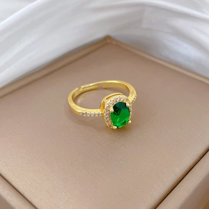 Adjustable gold ring featuring a green sapphire centerpiece and sparkling zircon accents